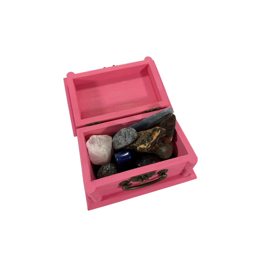 Open rose pink wooden treasure box filled with a selection of natural stones and crystals