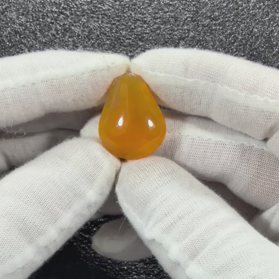 Close-up video of a one-of-a-kind Juniper Ridge Fire Opal cabochon from Oregon showing its polished surface, edges, and natural coloratio