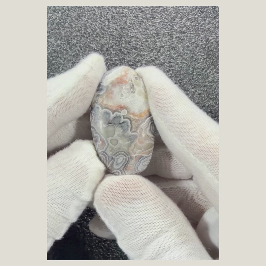 360-degree video of a genuine Crazy Lace Agate cabochon highlighting its unique swirling patterns and glossy polished surface.