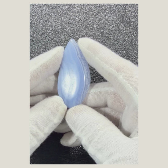 Product video displaying a polished African Blue Lace Agate cabochon from multiple angles to highlight its natural blue patterns.