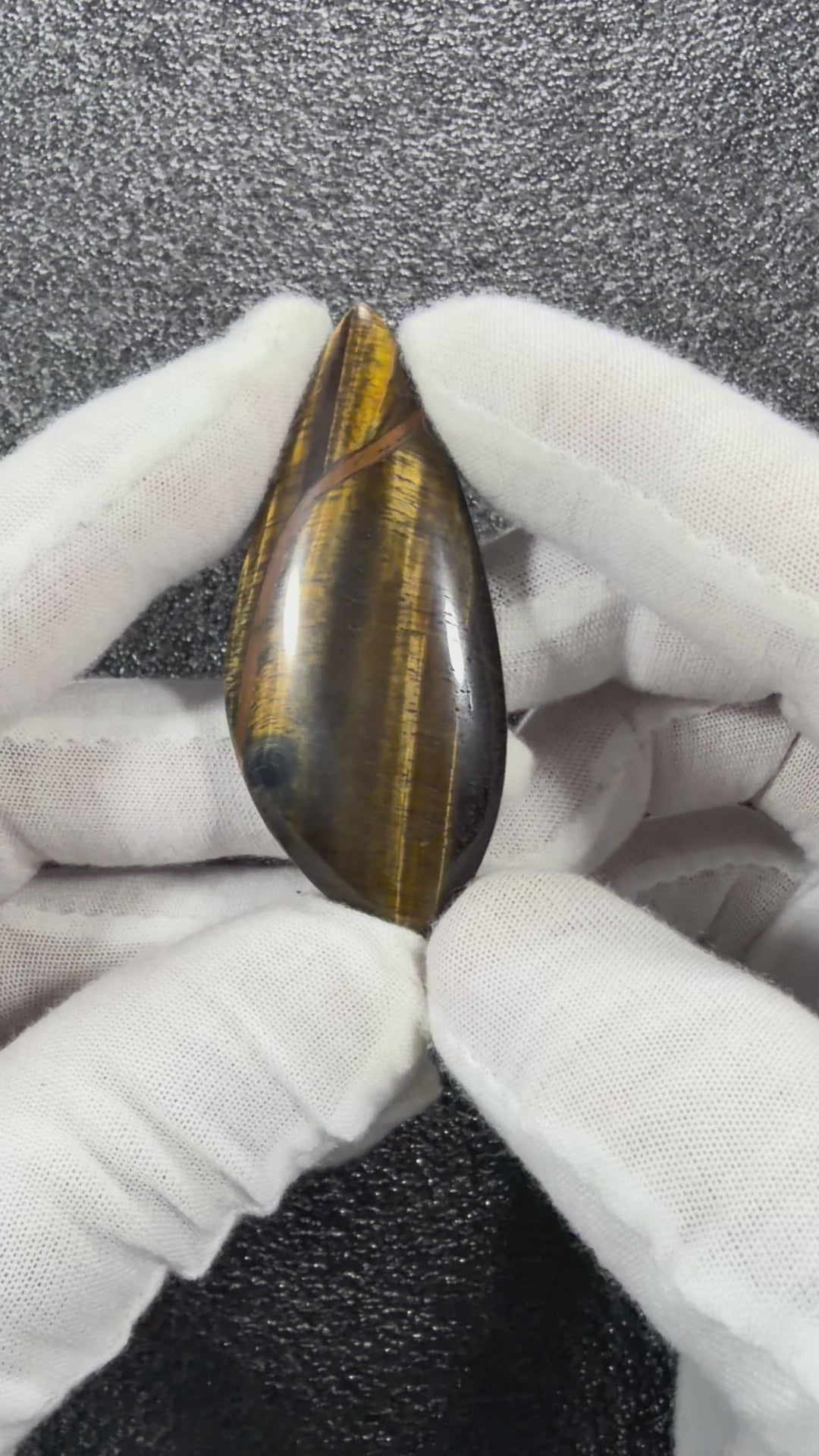 Video showcasing the natural Tiger's Eye cabochon from multiple angles, highlighting its golden chatoyancy, polished finish, and unique natural patterns.