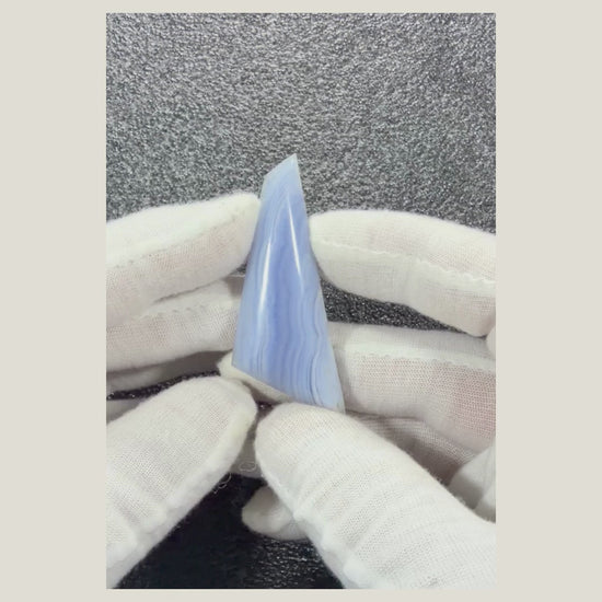Rotating video showcasing a genuine African Blue Lace Agate cabochon with calming blue hues and delicate white lace-like banding.