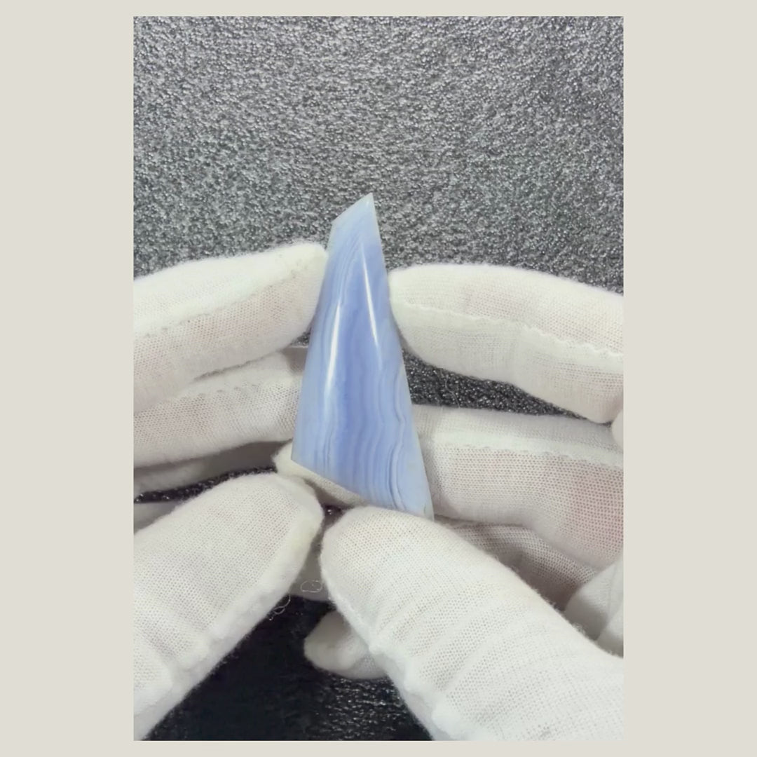 Rotating video showcasing a genuine African Blue Lace Agate cabochon with calming blue hues and delicate white lace-like banding.