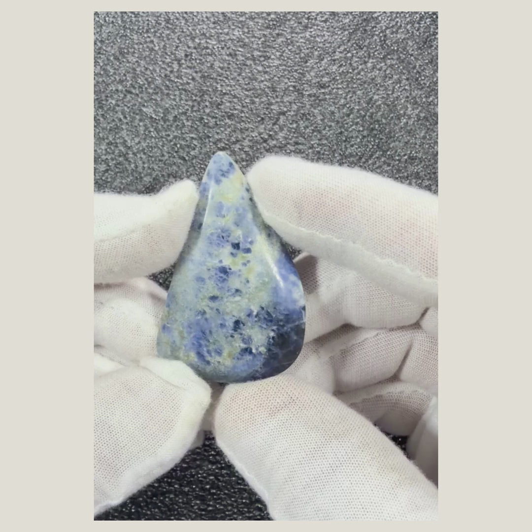 Close-up video of a natural Sodalite cabochon featuring rich blue hues, white marbling, and a glossy finish.